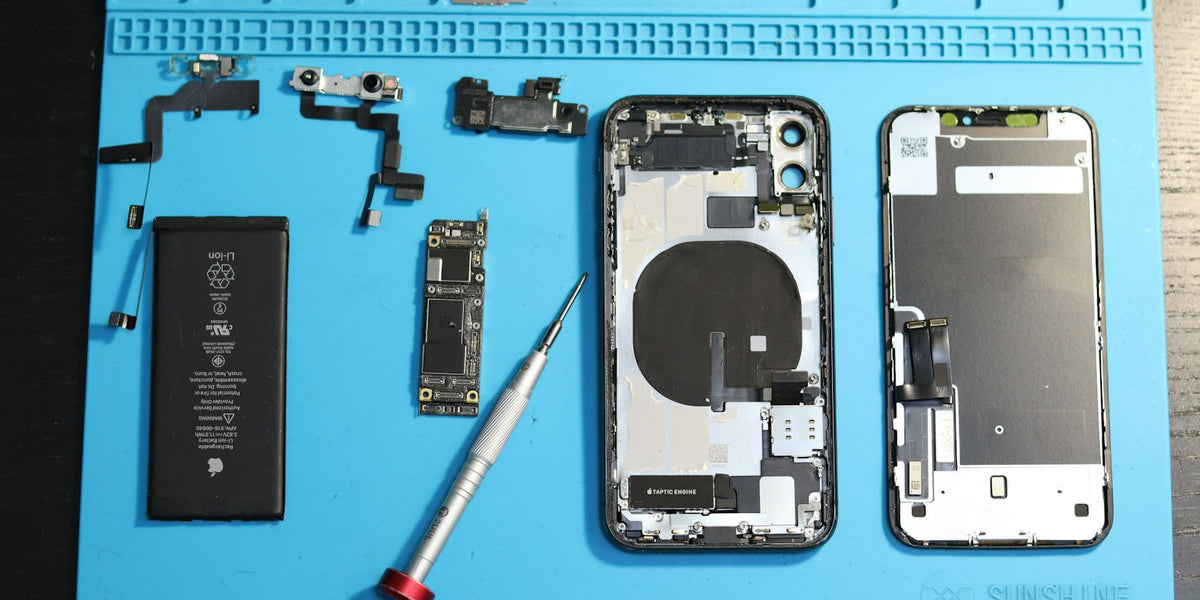 Smartphone repair bench with disassembled phone components and tools