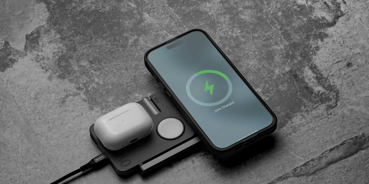 Smartphone, smartwatch, and earbuds charging together on a magnetic wireless charging pad